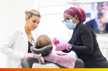 Cosmetic dentist holding veneers in Brooklyn to a young woman's smile
