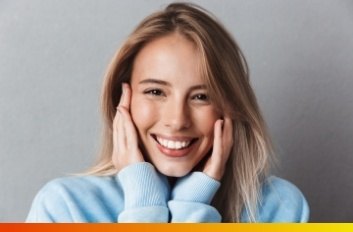 Smiling young woman holding her face