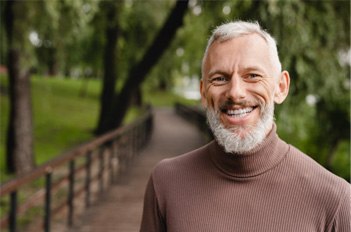 a man smiling after receiving his dentures