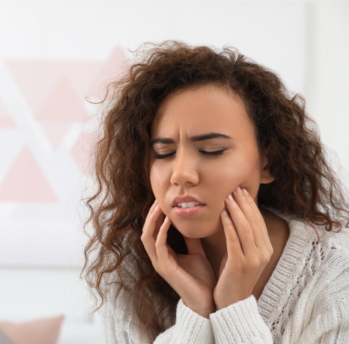 Woman with dental pain who needs emergency dentist in Brooklyn