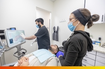 Dental team member showing a tablet screen to a patient