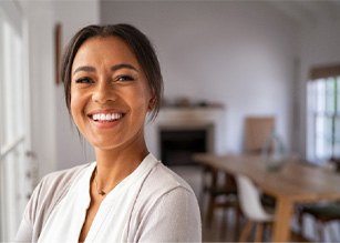 Woman standing in her kitchen and smiling