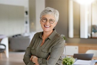 Senior woman standing and smiling at home