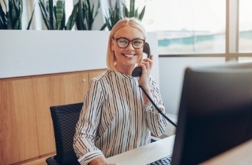 Smiling Brooklyn dental team member talking on phone