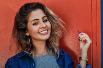 Smiling young woman with long blue fingernails