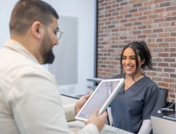 patient smiling at receptionist in Brooklyn