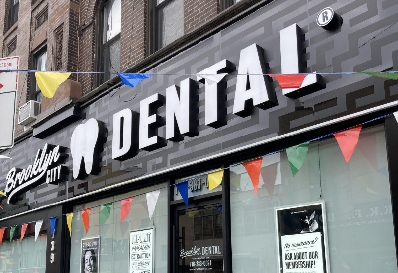 Colorful string of flags in front of Brooklyn City Dental