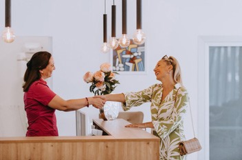 Front desk person shaking hands with a patient