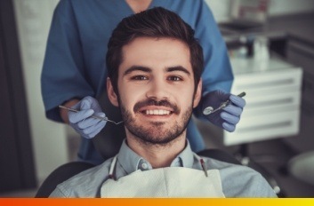 Young man smiling during preventive dentistry checkup in Brooklyn